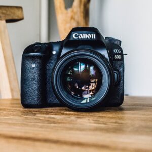 Canon DSLR camera on brown wooden table during daytime